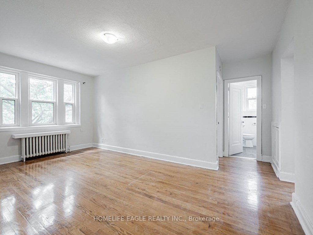 an empty living room with white walls and wood floors