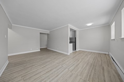 A room with wooden flooring and white walls.