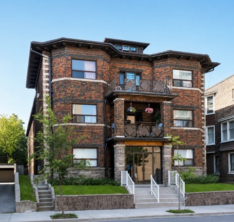A large red brick building with a balcony on the second floor.