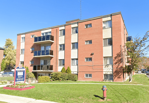 an apartment building with a fire hydrant in the grass