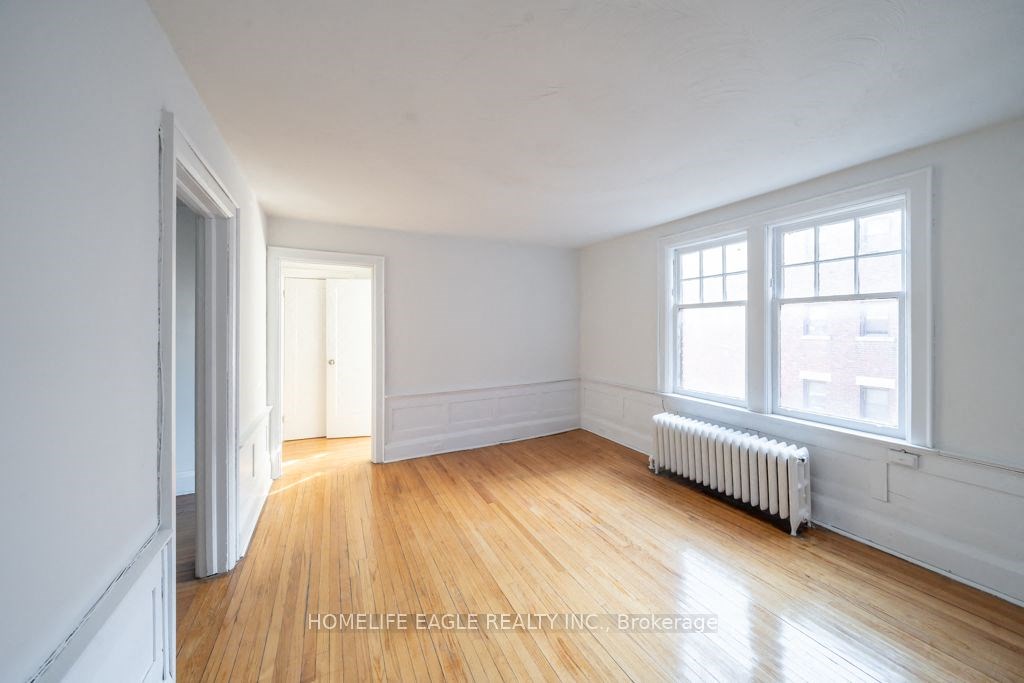 an empty living room with white walls and a wood floor