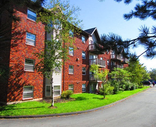 a red brick apartment building on the corner of a street