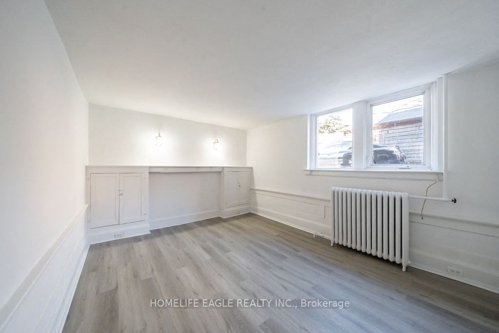 an empty living room with a radiator and a window