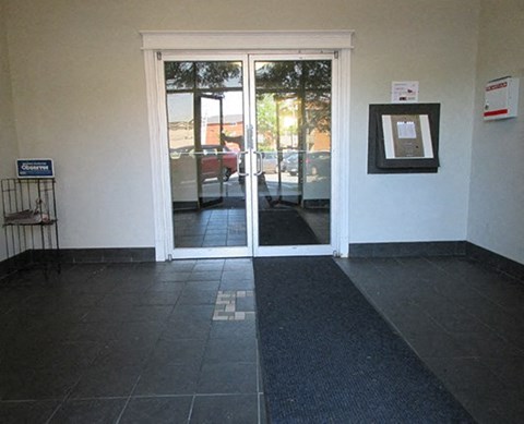 an empty room with doors and a black rug
