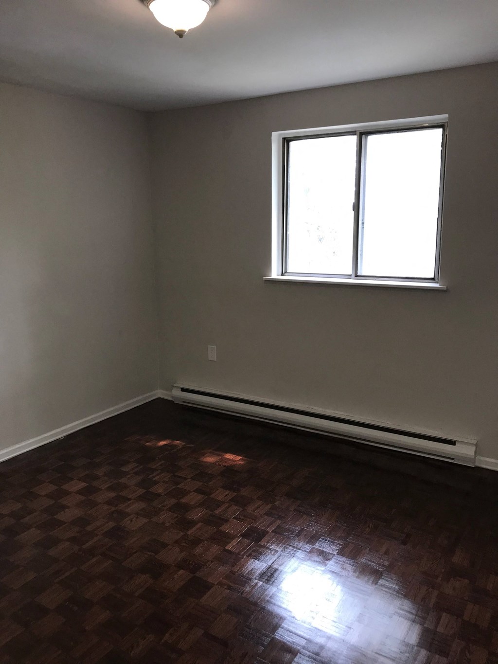 an empty room with wooden floors and a window