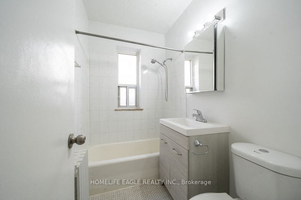 a white bathroom with a shower toilet and sink