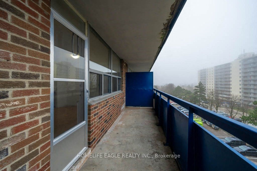 a balcony with a blue railing and a brick building