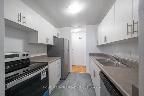 an empty kitchen with white cabinets and stainless steel appliances