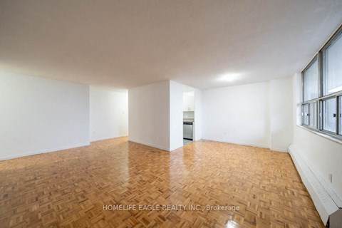 an empty living room with white walls and wood floors