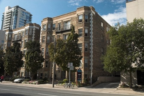 a brick apartment building on the corner of a city street