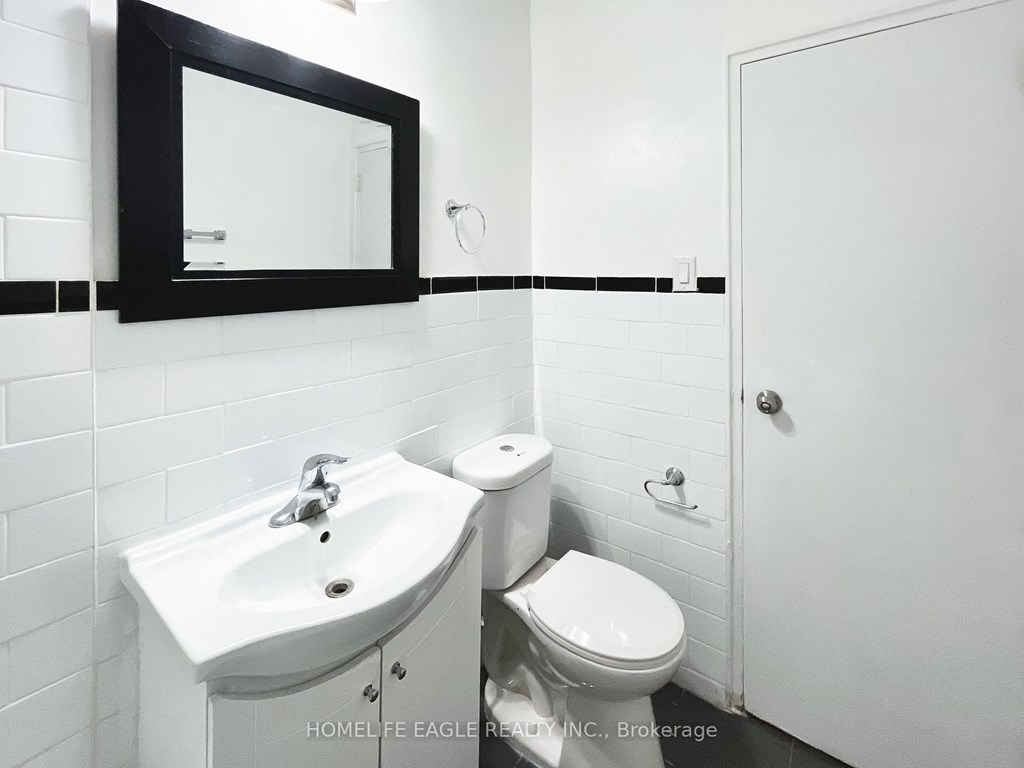 a white bathroom with a sink toilet and a mirror