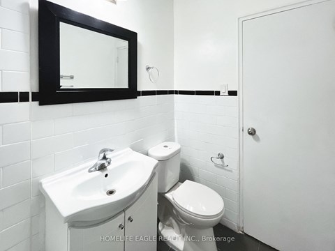 a white bathroom with a sink toilet and a mirror