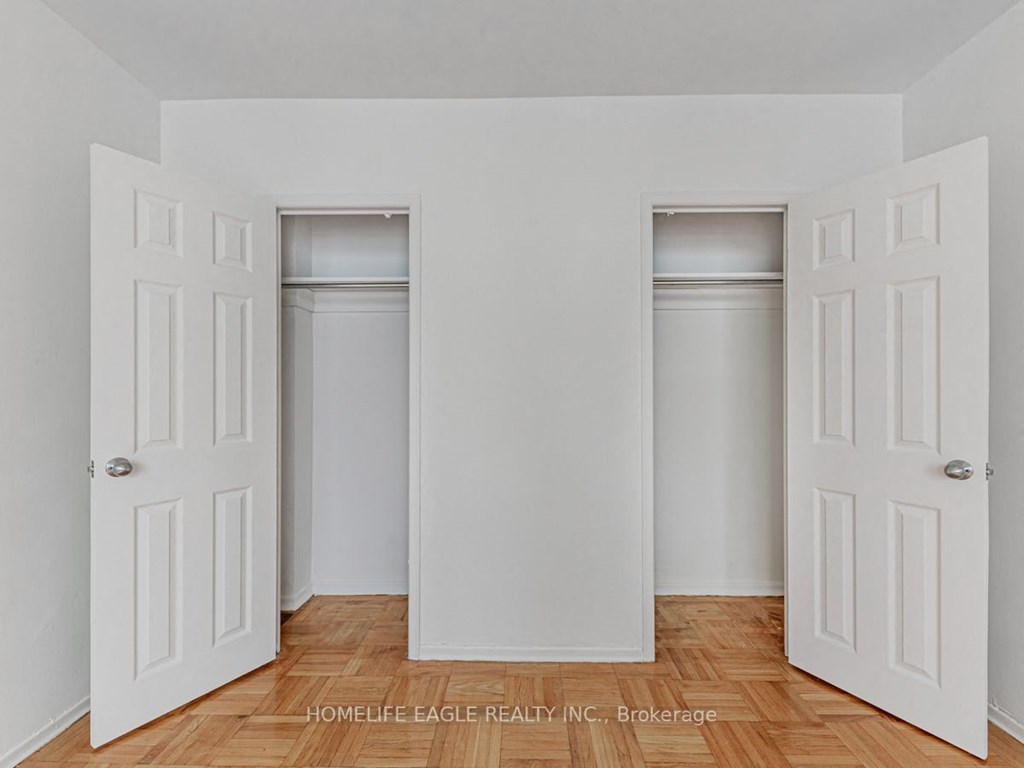 an empty room with white doors and a wood floor
