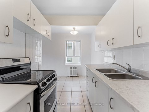 a kitchen with white cabinets and a sink and a stove