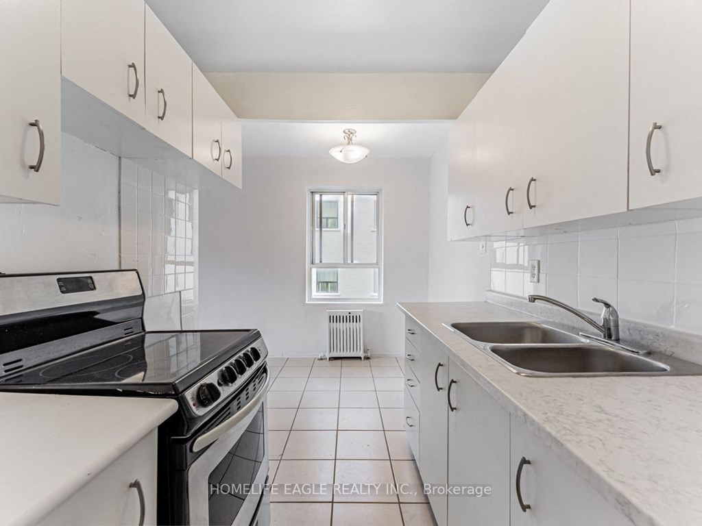 a kitchen with white cabinets and a sink and a stove