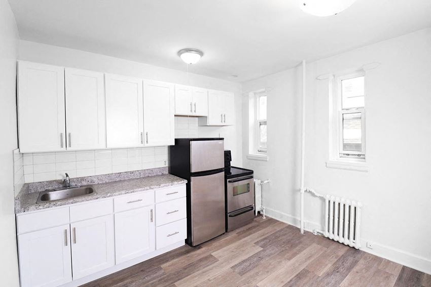 a kitchen with white cabinets and a stainless steel refrigerator