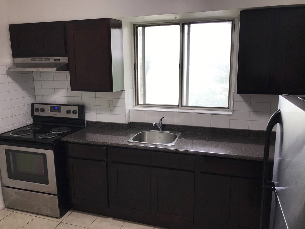 an empty kitchen with a sink and a window