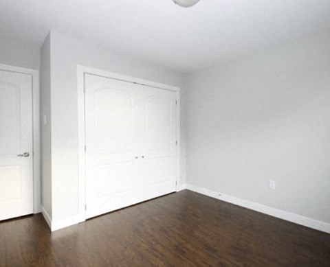 an empty living room with white walls and wood floors