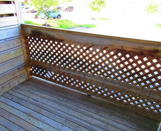 a wooden porch with a wooden railing and a window