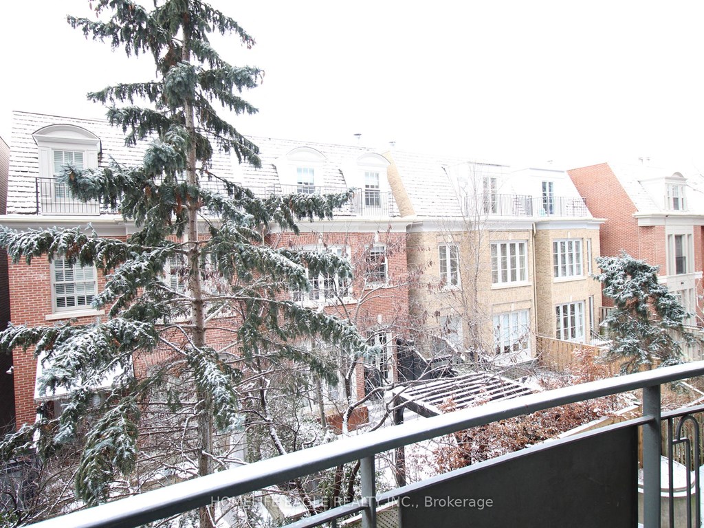 the view from our balcony of the snow covered trees and buildings