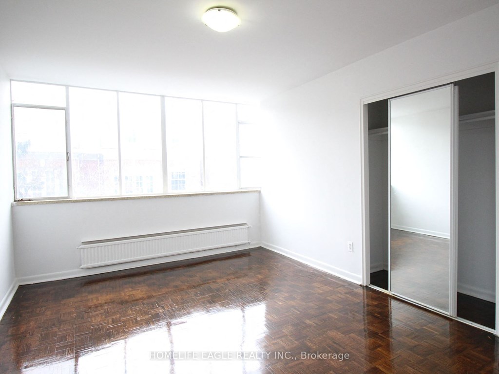 an empty living room with wood floors and a large window