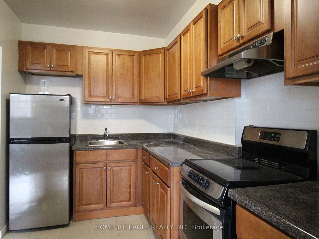 a kitchen with wooden cabinets and stainless steel appliances
