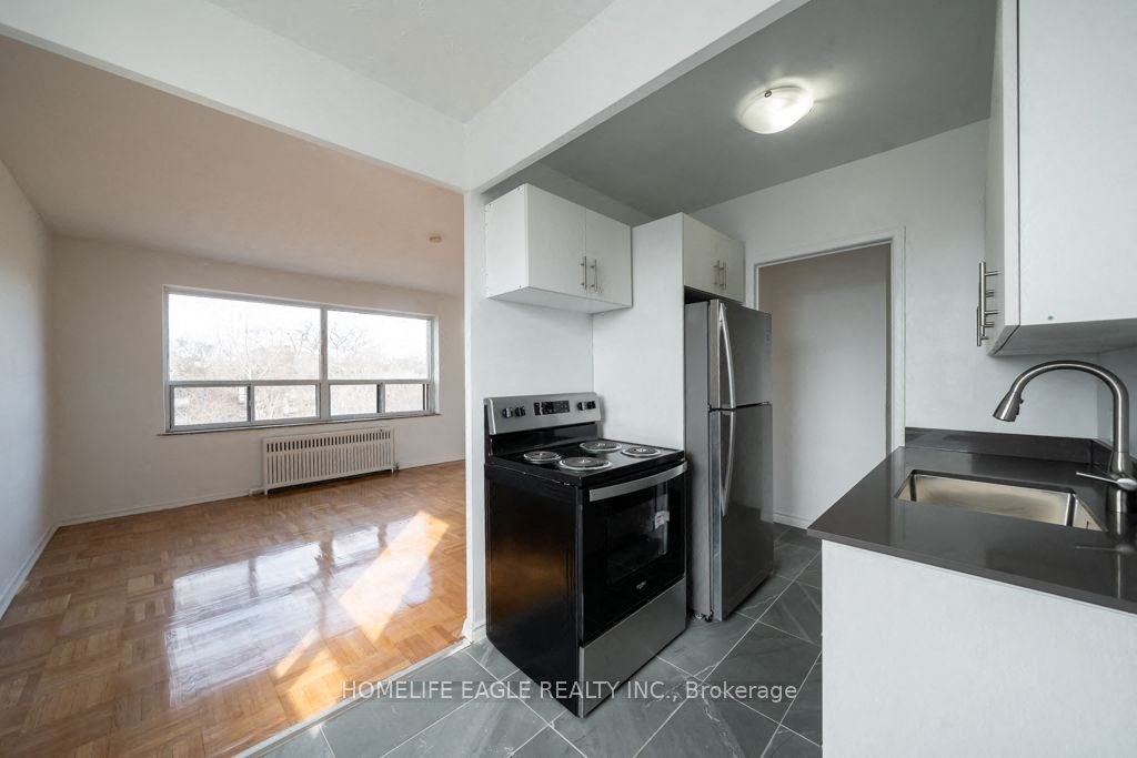 an empty kitchen with a stove and a refrigerator
