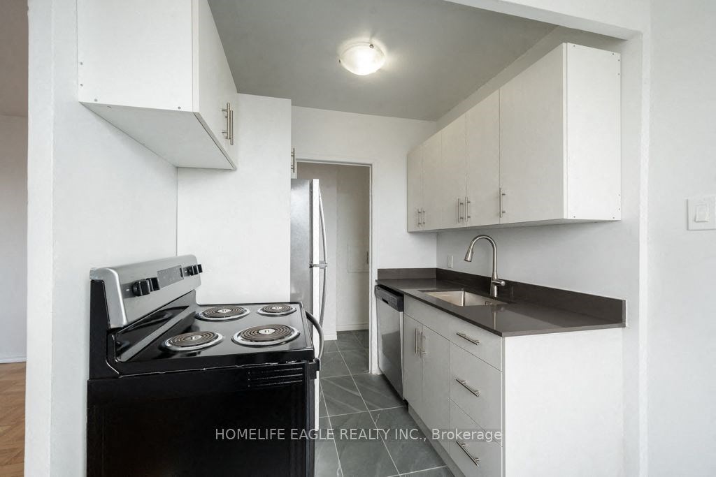 an empty kitchen with white cabinets and a black stove