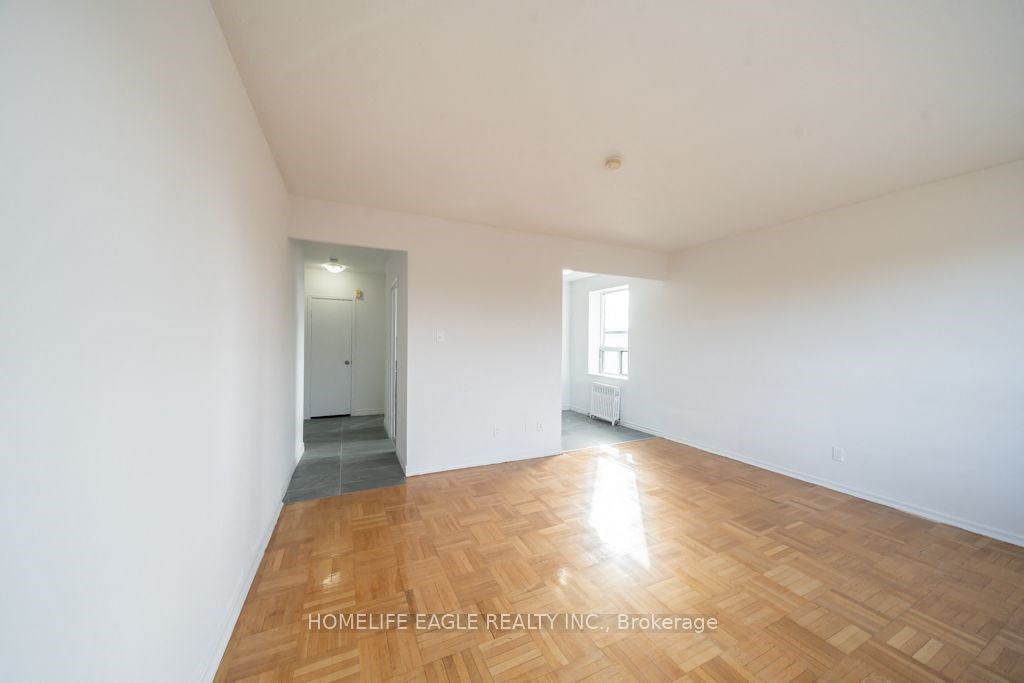 the living room of a home with white walls and wood floors