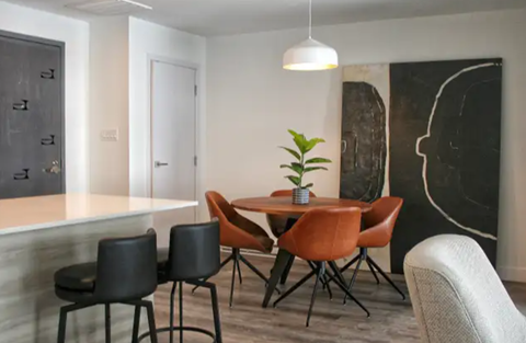 a dining room with a table and chairs and a potted plant