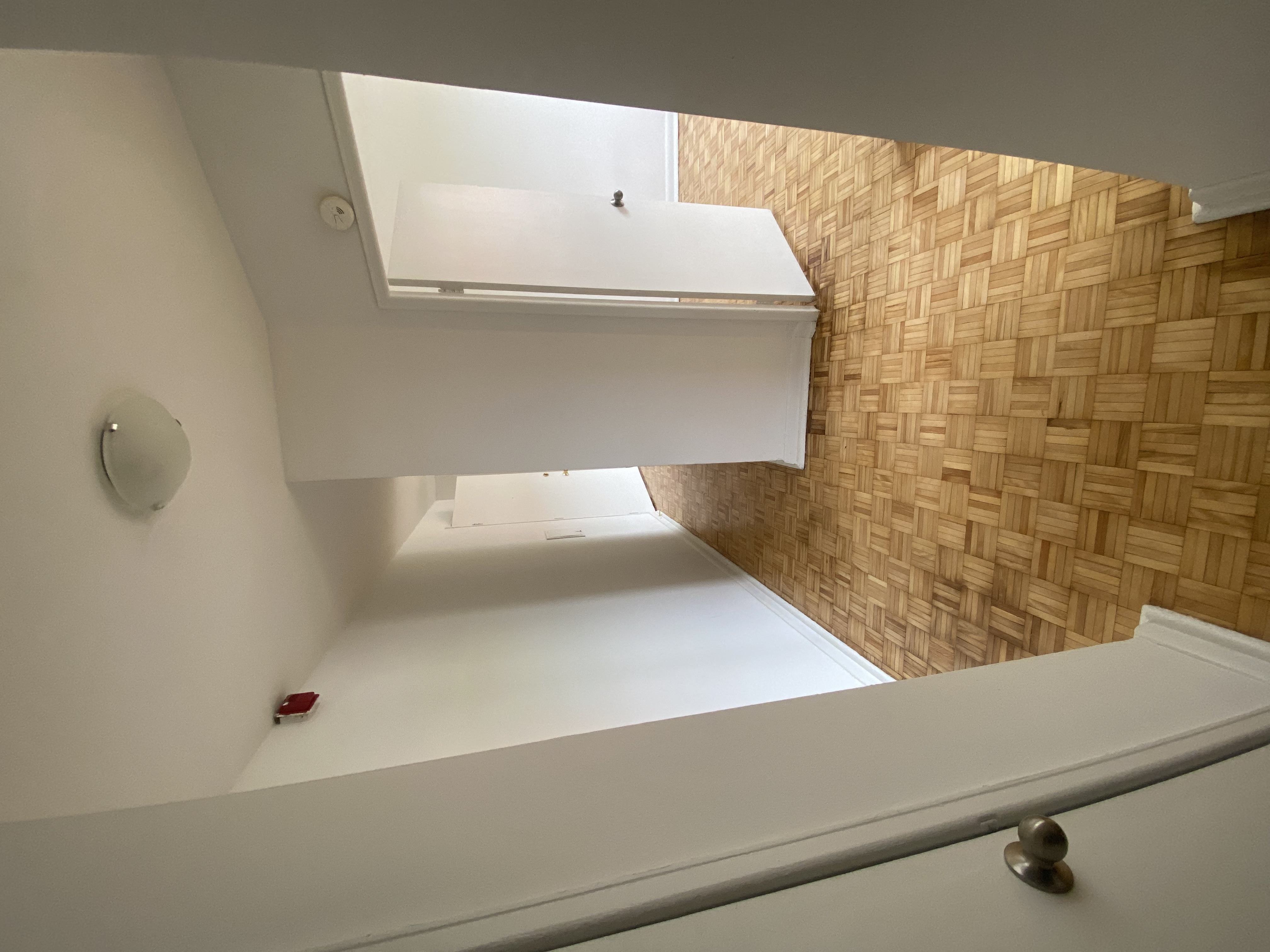 a view from the top of the stairs looking down into the bathroom