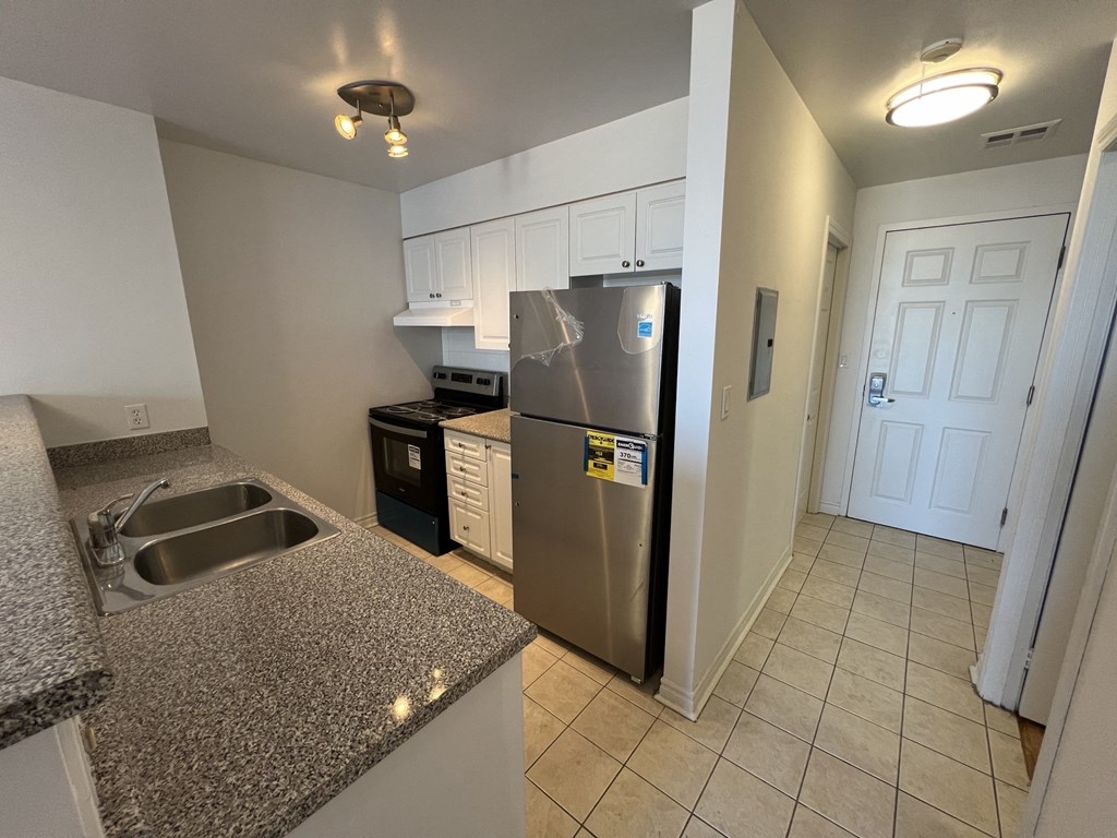 a kitchen with a stainless steel refrigerator and sink