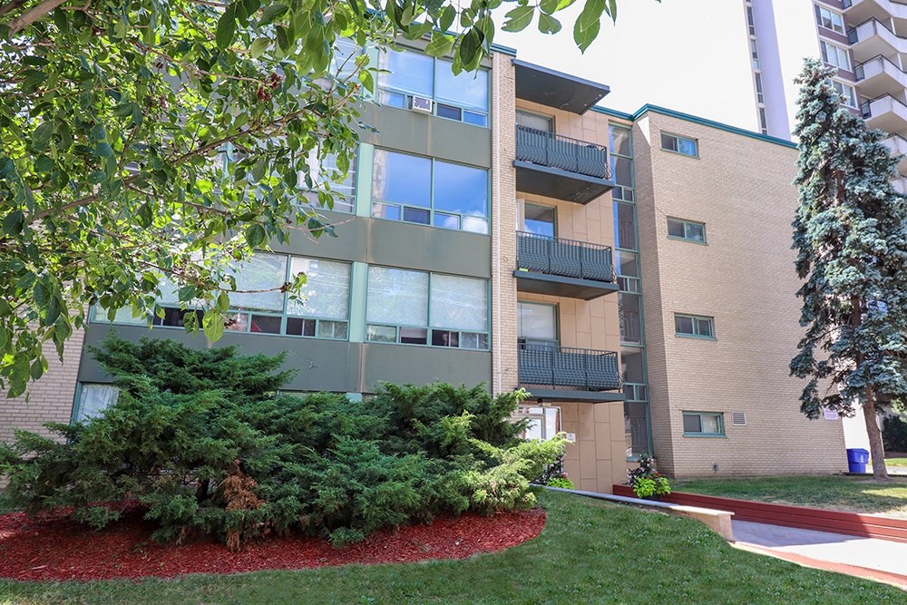 an exterior view of a building with grass and trees