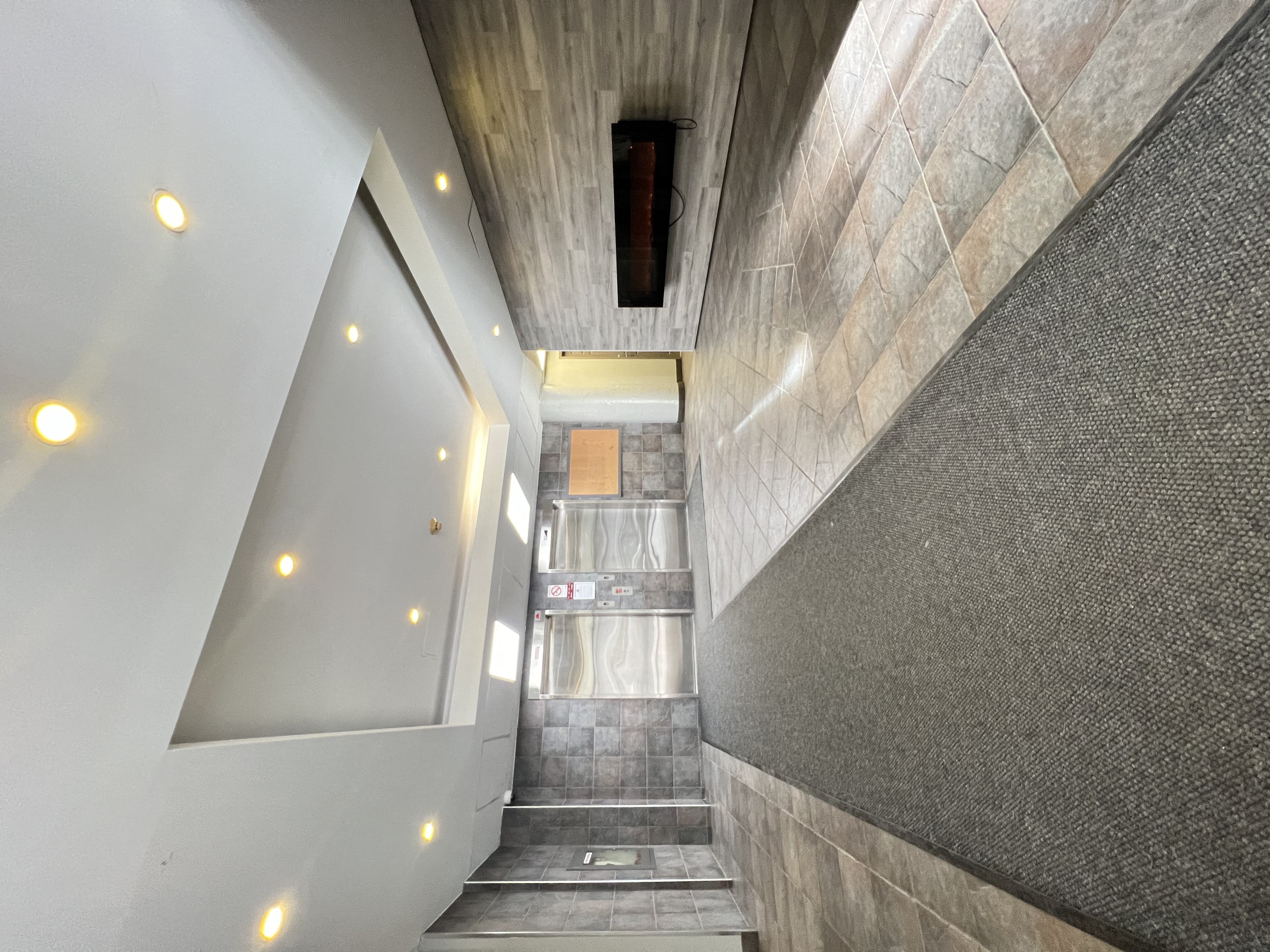 a view from the top of the stairs looking down into the lobby of a building