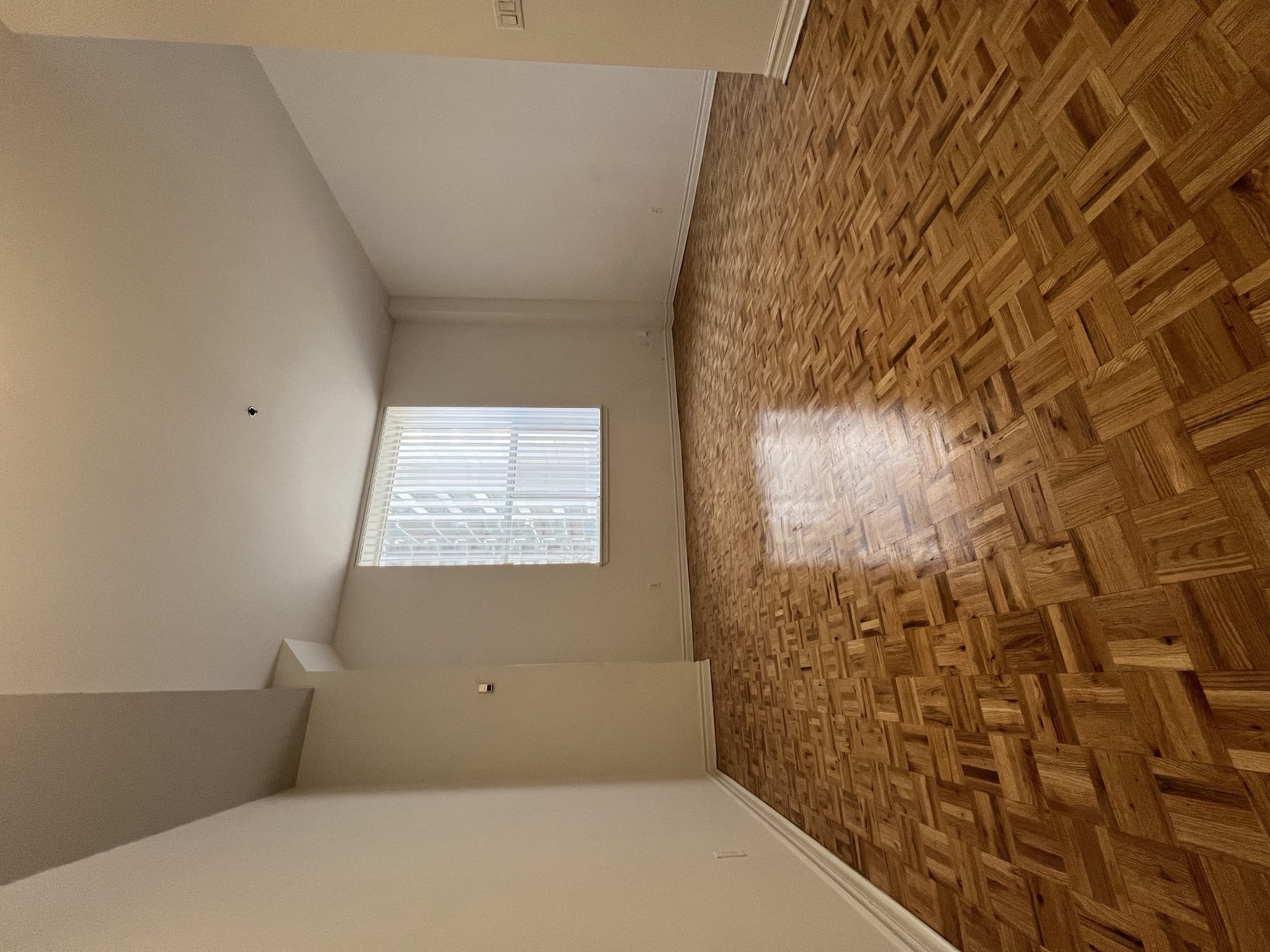 a small room with a window and a wooden wall