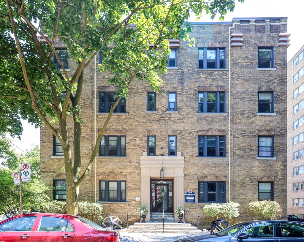 the exterior of a brick building with a tree in front of it