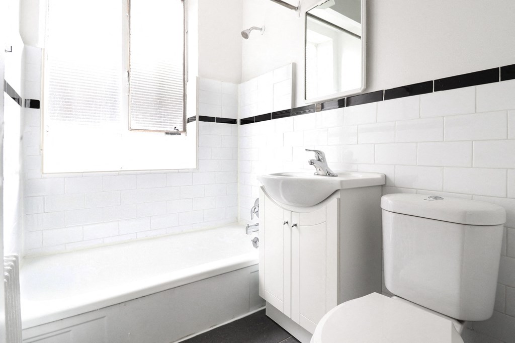 a white bathroom with a sink and a bath tub