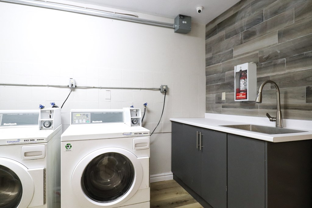 a washer and dryer in a laundry room with a sink