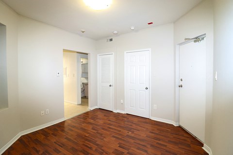 an empty living room with wood floors and white walls