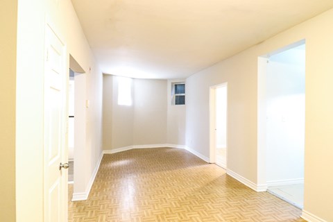 an empty living room with white walls and a wooden floor