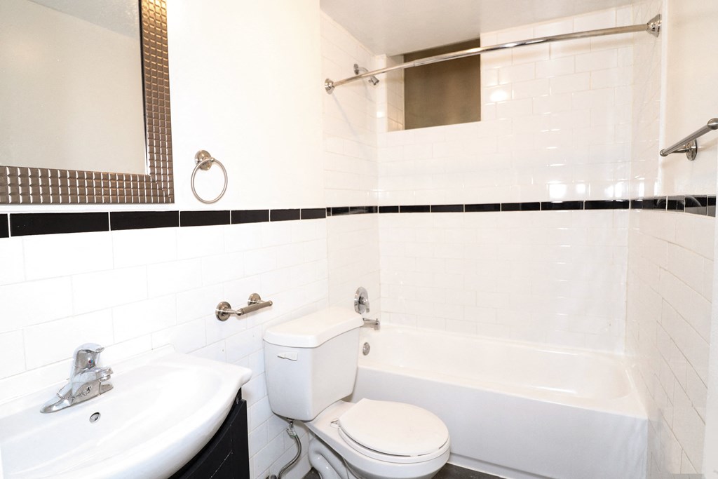 a bathroom with a toilet and a sink and a bath tub