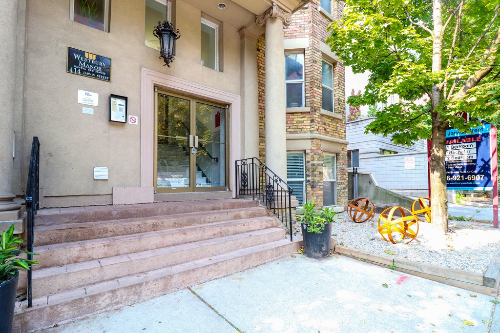 the front of a building with stairs and a glass door