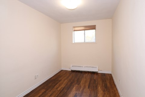 an empty room with white walls and a window