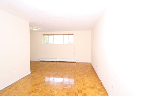 an empty room with wood floors and a window