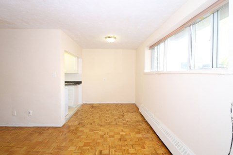 an empty living room with a wood floor and large windows