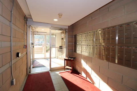 a locker room with doors and mailboxes and a red rug