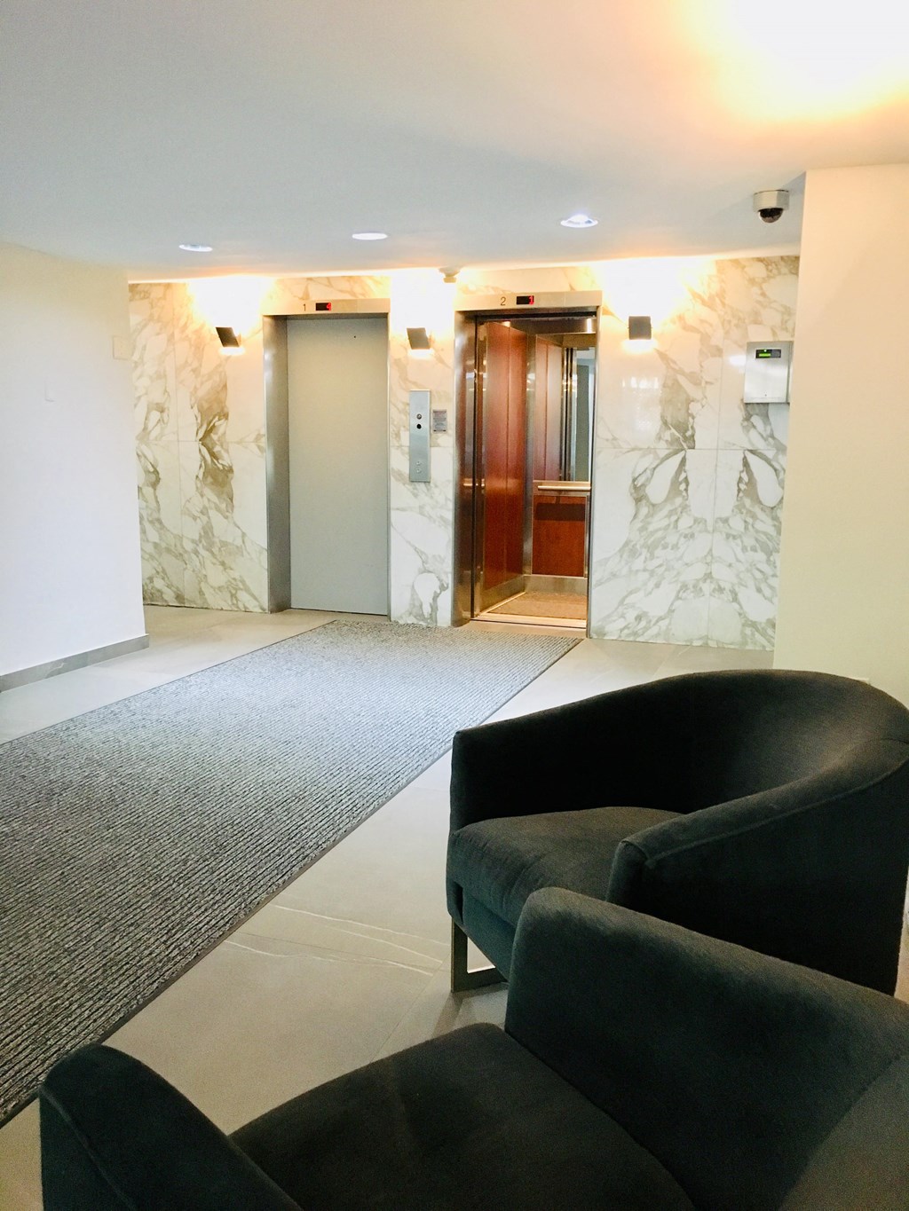 a seating area in the lobby of an office building with two chairs