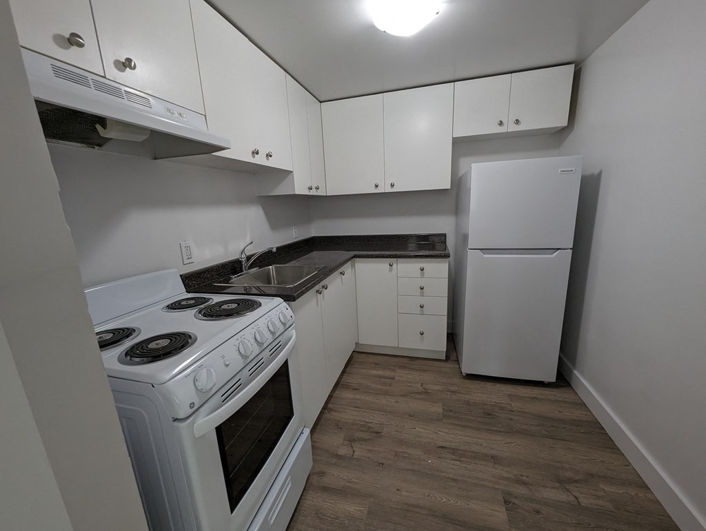 a kitchen with white appliances and white cabinets and a white refrigerator