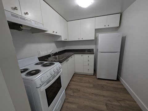 a kitchen with white appliances and white cabinets and a white refrigerator