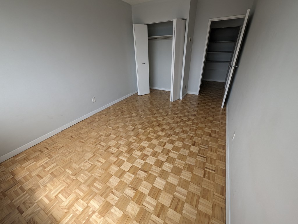 a empty room with wood flooring and a closet